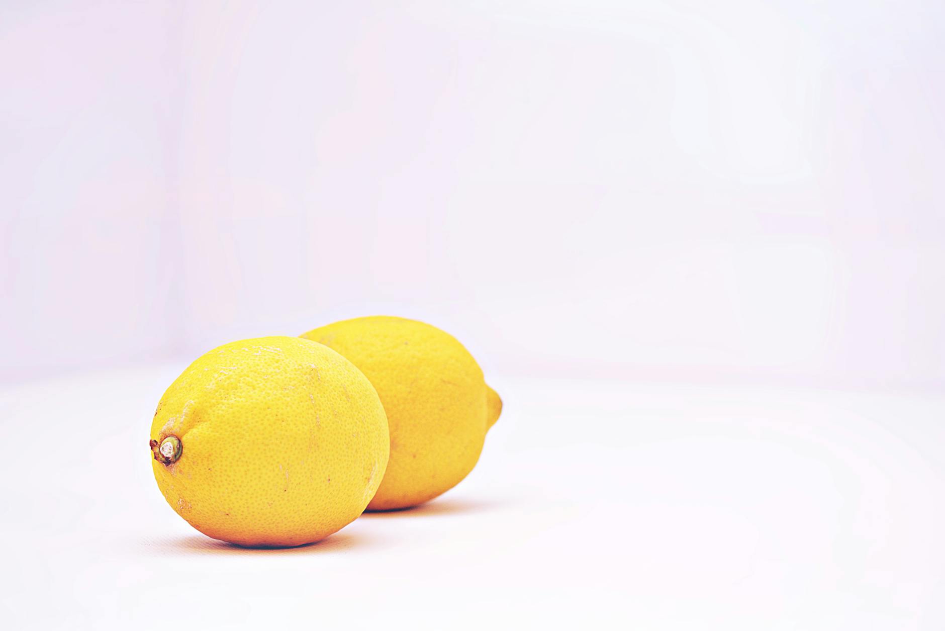 Two fresh lemons on a white background, bright and inviting
