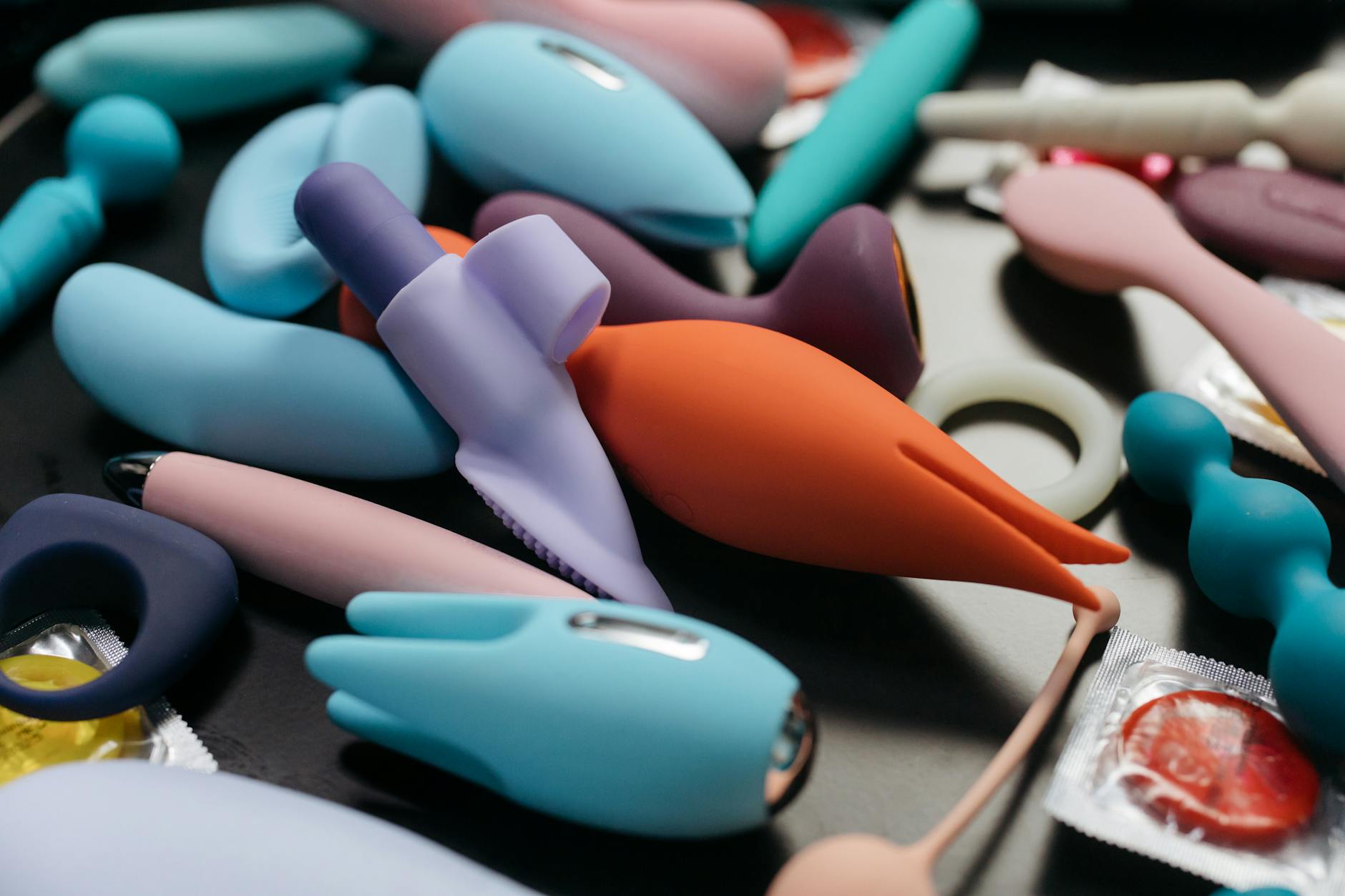 An array of vibrant adult toys including a lemon vibrator and rings displayed close-up