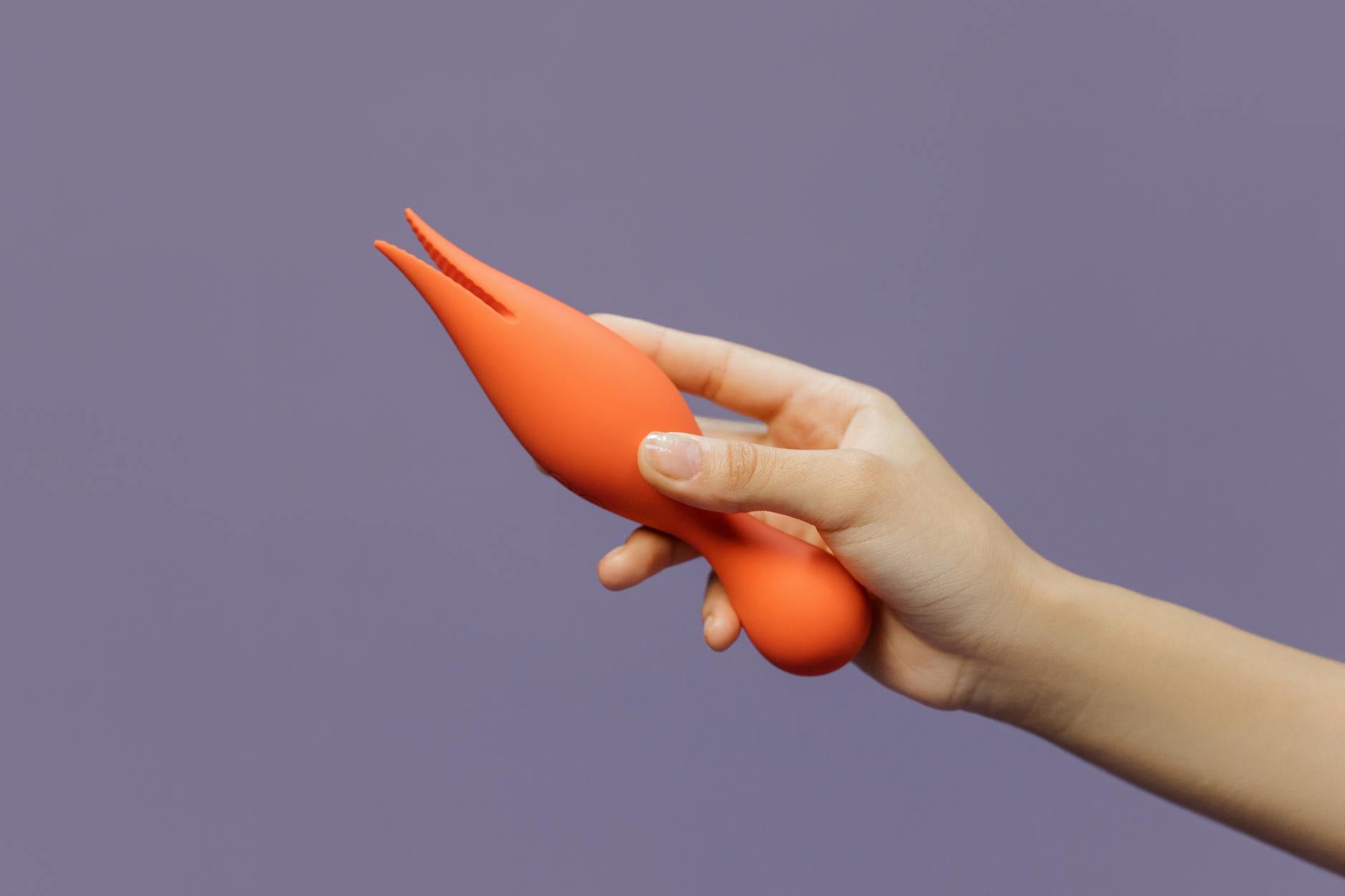 A hand holding a lemon vibrator against a minimalist purple backdrop, symbolizing the return of sensual awareness