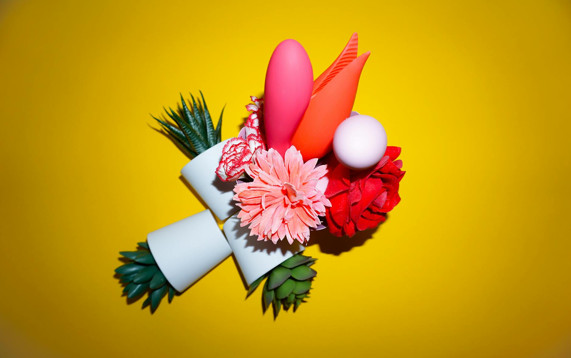 Colorful clitoral vibrators and personal massagers arranged on a bright yellow background